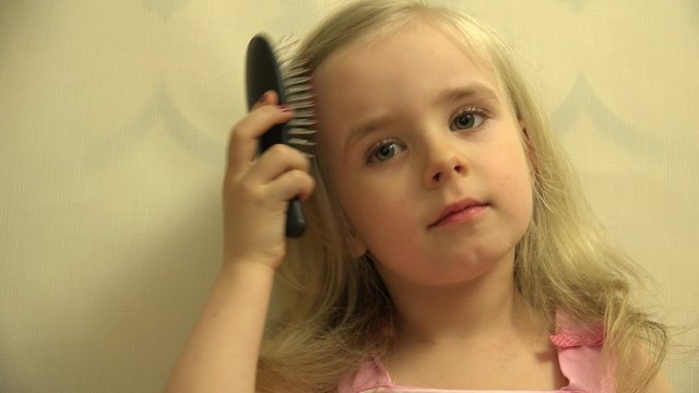 Girl Toddler Child Hair Dresses herself with a Hair Comb and Bru. 4K UltraHD video.