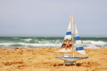 sailboat on sea sand and ocean horizon
