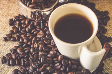 Cup Of Espresso / Cup Of Espresso And Stainless Scoop With Roasted Coffee Beans Scattered Beans On Sack Background.