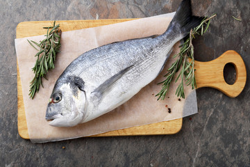 raw fish and herbs on cutting board