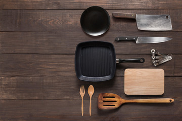 Various kitchenware utensils on the wooden background for cookin