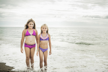 Girls smiling in waves on beach