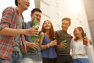 Group of Vietnamese young people drinking beer and chatting outdoors