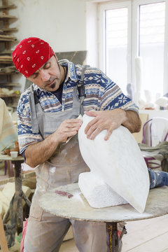 sculptor sanding marble with sandpaper
