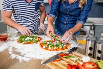 Smiling couple preparing pizza