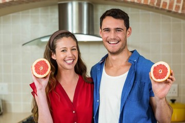 Couple holding slices of blood orange