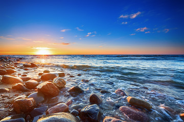 Obrazy na Plexi  Zachód słońca nad Morzem Bałtyckim. Kamienista plaża w Rozewiu.