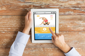 close up of hands with sport app on tablet pc
