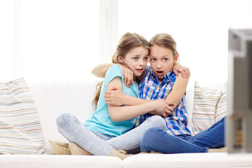 scared little girls watching horror on tv at home