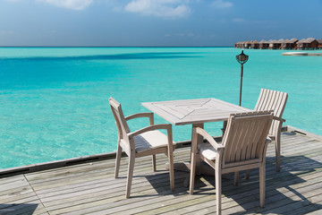 outdoor restaurant terrace with furniture over sea