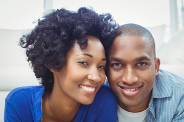 Happy couple lying on the floor and smiling at the camera