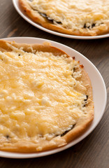 Homemade pies with cheese on a wooden table