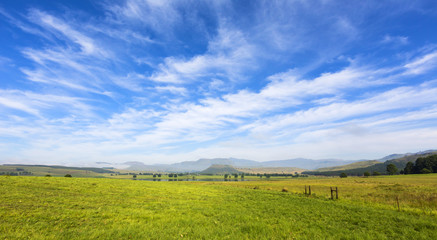 Fototapeta na wymiar Thin clouds over green pastures