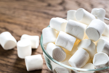 Fototapeta na wymiar Bowl of marshmallows on the wooden background