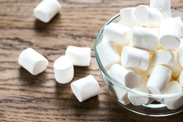 Fototapeta na wymiar Bowl of marshmallows on the wooden background