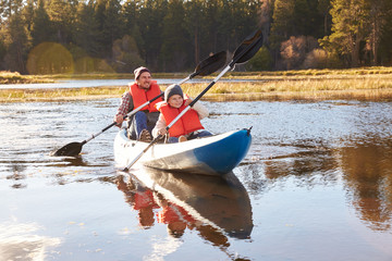 Father and son kayaking on lake, California, USA