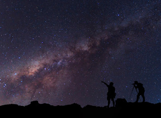 Naklejka na ściany i meble Star-catcher. A person is standing next to the Milky Way galaxy