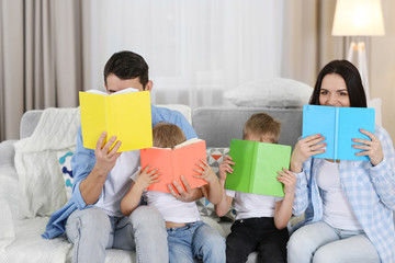 Fototapeta na wymiar Family concept. Happy family with colourful books in the room