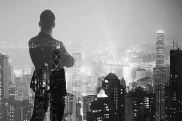Photo of stylish adult businessman wearing trendy suit and looking night city. Double exposure,...
