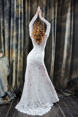 Fototapeta premium portrait of pretty bride in wedding dress with hands up