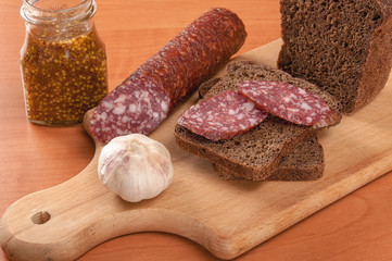 Sausage sliced with knife on a wooden table