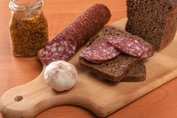 Sausage sliced with knife on a wooden table