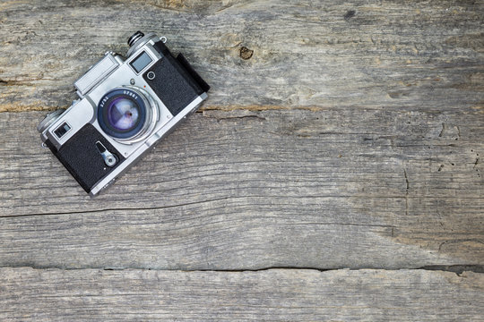 Old analog camera on wooden surface