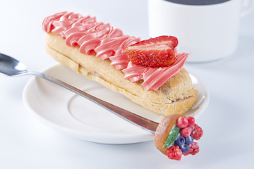 eclair with cream and strawberries closeup