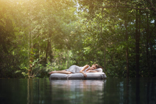 A hidden place. Sleeping woman in deep forest lies on airbed