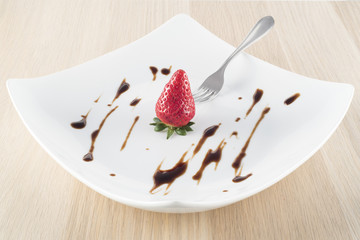 Strawberry with balsamic vinegar on white plate