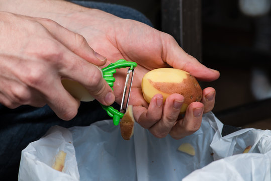 close-up hands peeling potatoes