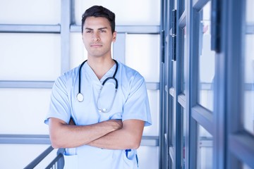 Serious male doctor standing with arms crossed