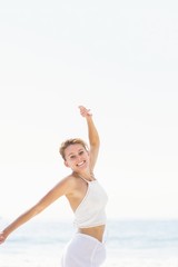 Fototapeta na wymiar Portrait of beautiful woman stretching her arms on the beach