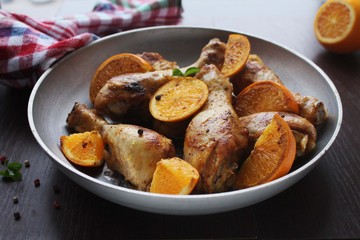Roasted chicken legs in cast iron skillet, selective focus