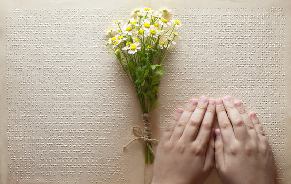 
reading Braille with a bouquet of wild flowers