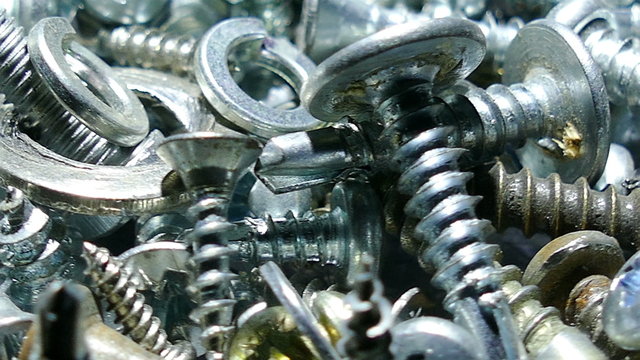 Group of  bolts ,  screw, nuts, rotates. 4K macro  slow rotation 