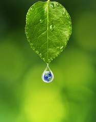 Earth in water drop under green leaf, Elements of this image furnished by NASA