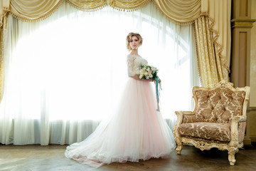 Fototapeta na wymiar full length view on beautiful woman posing in a wedding dress