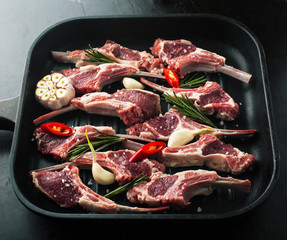 Raw fresh lamb meat with spices on the grill pan