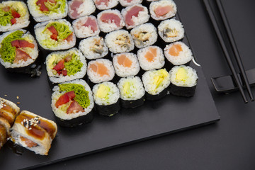 Sushi set on a black plate over dark background
