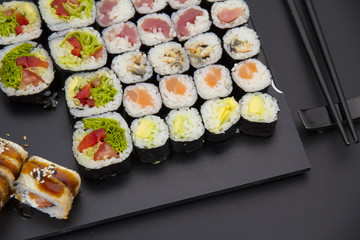 Sushi set on a black plate over dark background