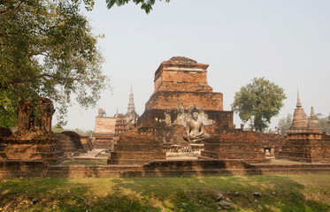 Fototapeta na wymiar Ancient ruins with stone Buddha statues at Sukhothai historical park