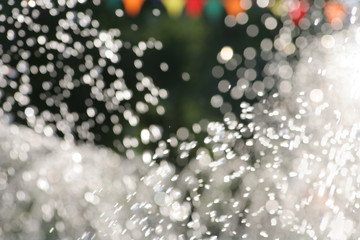Water drops fly in the air outdoors. Blurred summertime wallpaper a lot of copyspace