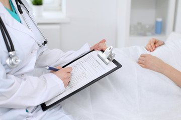 Close-up of a female doctor holding application form while consulting patient