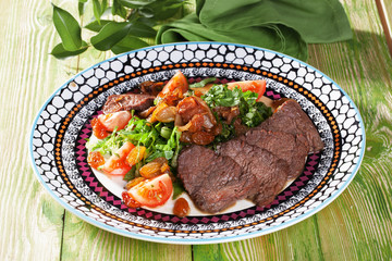 slices of baked meat with a salad vegetables still life wooden table green Provence restaurant atmosphere