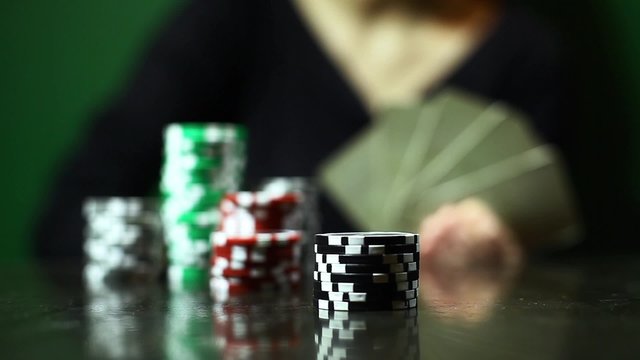 Person pushing some poker chips towards camera.