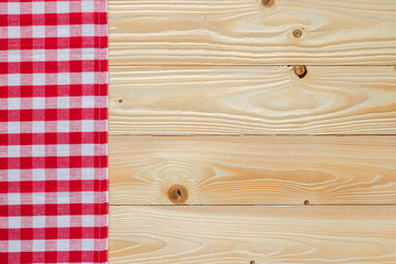 wooden table with red squared textile tablecloth, top view, horizontal