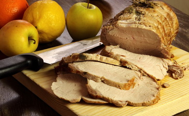 roast pork slices on wooden cutting board