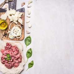 homemade burgers, ground beef, herbs, oil and onion border ,place for text  on wooden rustic background top view