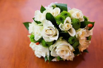 Beautiful bridal bouquet of flowers and wedding rings
